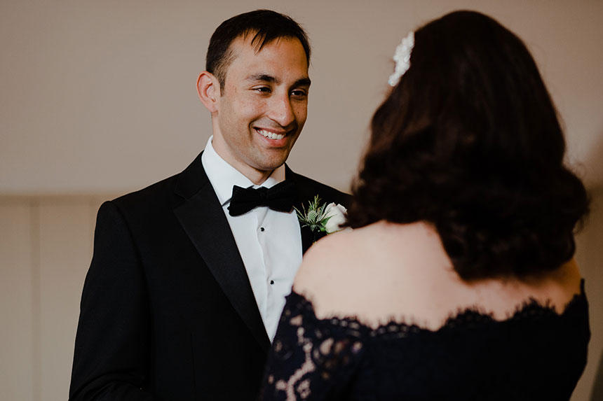 bride looks at groom in his wedding suit