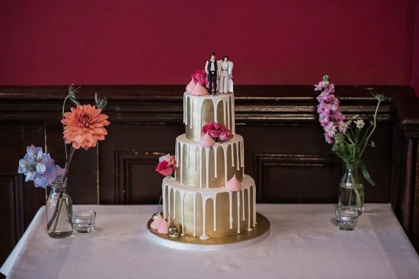 cake toppers on top of gold wedding cake